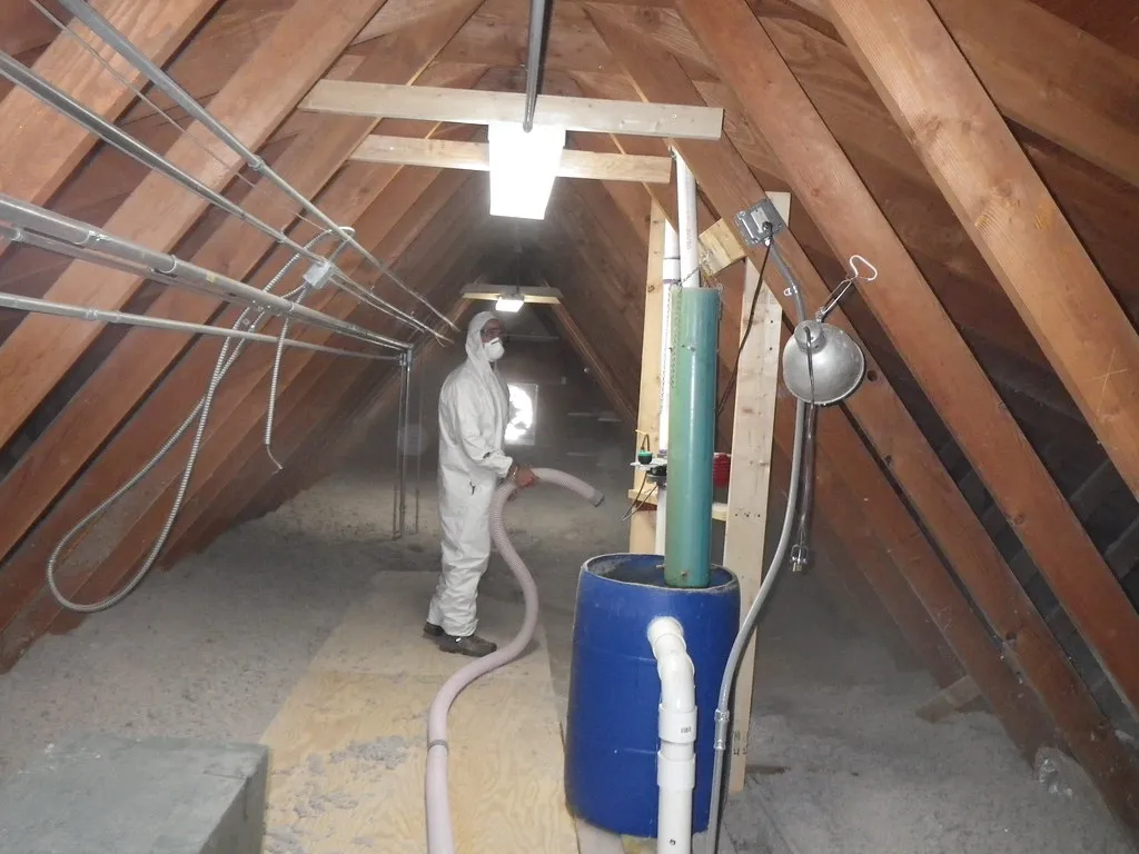 Installer blowing loose-fill insulation into an attic